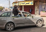 An armed and masked member of the so-called "Popular Committees of Protection" patrols the streets of Rafah on Wednesday, March 6.
