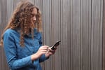 In this undated, public domain file photo, a young person is pictured on their mobile phone. For the last five years, the Safe Social Spaces program has been reaching out on social media to youth who may be at risk of self-harm or suicide. SSS is run by the Oregon Lines for Life nonprofit.