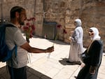 A member of Tag Meir, an Israeli group working against hate crime and racism, hands out flowers to residents of the Old City before the march begins.