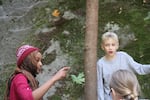 Class Of 2025 students Munira (left, in maroon) and Dude (in gray) take a break from Outdoor School field study at the Arrah Wanna site near Welches, Ore.