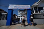 Health officials come out of Nana Backpackers Hostel after checking documents in Vang Vieng, Laos, on Friday.