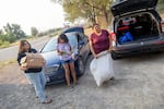 Alejandra Hernandez, from left, along with AnaMaria Morales and Arcadia Hernandez, deliver clothes and hot weather supplies to agricultural workers in Hammett, Idaho.