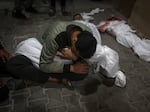 A Palestinian youth mourns his relative killed in the Israeli bombardment of the Gaza Strip, at the morgue of the Kuwaiti Hospital in Rafah refugee camp, southern Gaza Strip, early Saturday, April 20, 2024.