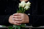 People hold flowers as they wait to view the cortege carrying the coffin of the late Queen Elizabeth II in Ballater, United Kingdom.