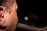 In this photo provided by NASA, Artemis II commander and NASA astronaut Reid Wiseman looks out one of the Orion spacecraft's main cabin windows at the Moon ahead of the crew's lunar flyby on April 6, 2026.