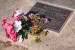 Flowers rest on the grave site for Don and Gail Patterson.
