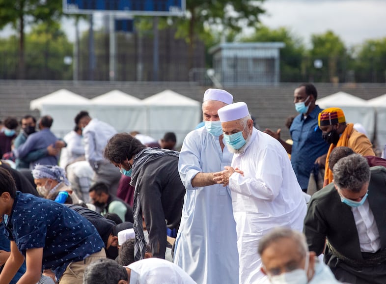 Community members greet one another as the sermon ends and Eid Al-Adha festivities begin.