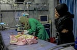 A nurse tends to a baby at Kamal Adhwan hospital in Beit Lahia, Gaza.