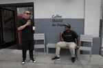 Owner of Deadstock Coffee, Ian Williams (right), shares a laugh with a friend outside his sneaker-themed coffee shop in Chinatown, Portland. 