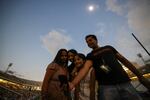 Mindy and Jas Gill take photos with daughter Jaclyn, 15, and Jasmine, 10 during the totality Monday at the Dallas Cotton Bowl Stadium.