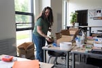 Kelly Holt, a photography and yearbook teacher, unpacks a fake wooden plant while a real plant sits in the back as she sets up her new classroom at the newly rebuilt Beaverton High School on the first day of the 2026-2027 school year in Beaverton, Ore., on Aug. 26, 2026. Holt’s husband made the wooden laser-cut plant for her last year, when her classroom had no windows for real plants. She’s begun getting real plants for her classroom now that she has four large windows.