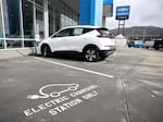 A brand new Chevrolet Bolt sits on the sales lot at a car dealership in Colma, Calif., on Oct. 7, 2021. President Biden's climate and health care bill revamps a tax credit available for buyers of electric cars.