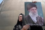 An Iranian protester holds up a poster of the Supreme Leader Ayatollah Ali Khamenei.