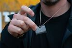 Gil Dickman holds half a dog tag that reads, "Our heart is held hostage in Gaza." Dickman's relative, Yarden Roman-Gat, heard his voice on Israeli public radio when she was held captive in Gaza.