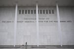 A person walks a dog in front of the Kennedy Center in Washington, D.C., on Jan. 10, 2026.