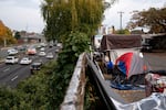 RVs and tents line a street above the highway at an encampment of unhoused people in Portland, Ore., on Oct. 31, 2025.