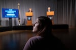University of Oregon journalism student Gretchen Wackler watches the candidate speaking timer during the gubernatorial debate in Eugene, Ore., at the University of Oregon on Thursday, Oct. 1, 2026. Debating were Democratic incumbent Gov. Tina Kotek and Republican state Sen. Christine Drazan.  Wackler used yellow and red cards to signal the candidates as the time counted down. 
