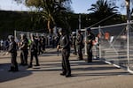 Police officers stand guard as they close the gate of the main entrance of Dodger Stadium faced with protesters on Thursday.