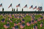 Activists from the COVID Memorial Project mark the deaths of 200,000 lives lost in the U.S. to COVID-19 after placing thousands of small American flags on the grounds of the National Mall in Washington, Tuesday, Sept. 22, 2020.