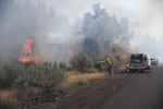 In a photo provided by Oregon State Fire Marshal, firefighters fight the Cram Fire east of Madras.