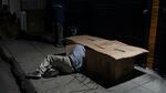 David Hernandez, 62, crawls into his bed made with cardboard boxes in Los Angeles last week. Los Angeles Mayor Karen Bass has declared a state of emergency to grapple with the city's homeless crisis.