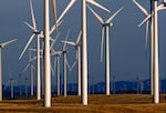 FILE - This May 6, 2013 file photo shows a wind turbine farm owned by PacifiCorp near Glenrock, Wyo. PacifiCorp owns Oregon's second-largest electric company and was offered up to $3.52 billion on Thursday to finance construction of 700 miles of transmission lines in Oregon, Idaho, Utah and California. Oregon's power grid needs upgrades to handle the added load of wind and other renewables.