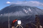 Carolyn Driedger peeks at the timelapse camera set up at the observation post known as Coldwater 11, during her visit with geologist David Johnston, May 17, 1980.