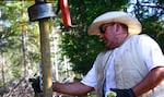 Pedro Ibarra ensures a post for Mill-Mar Ranch's new wolf fence goes in straight.