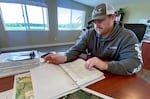 Stewart Kircher opens a binder detailing how the dairy farms stores and utilizes nutrients from the manure produced by its 2,000 cows.