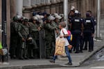 A street vendor walks by members of the Bolivarian National Guard ahead of President Nicolas Maduro's swearing-in for a third term, in Caracas, Venezuela