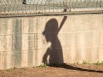 In this file photo, the shadow of a player on a high school JV girls softball team is pictured in this file photo.