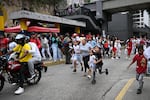  People run into a street following an earthquake in Caracas.