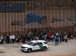 Migrants and asylum seekers wait to be processed by the Border Patrol between fences at the US-Mexico border seen from Tijuana, Baja California state, Mexico, on June 5, 2024.