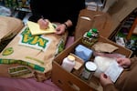 Mutual aid volunteers, Annie, left, and Lorelit, organize food and home staple items, most of which were donated or bought with donation funds the group gathered, for people in hiding due to U.S. Immigration and Customs Enforcement raids in a volunteer’s Hillsboro, Ore., home on Dec. 5, 2025.