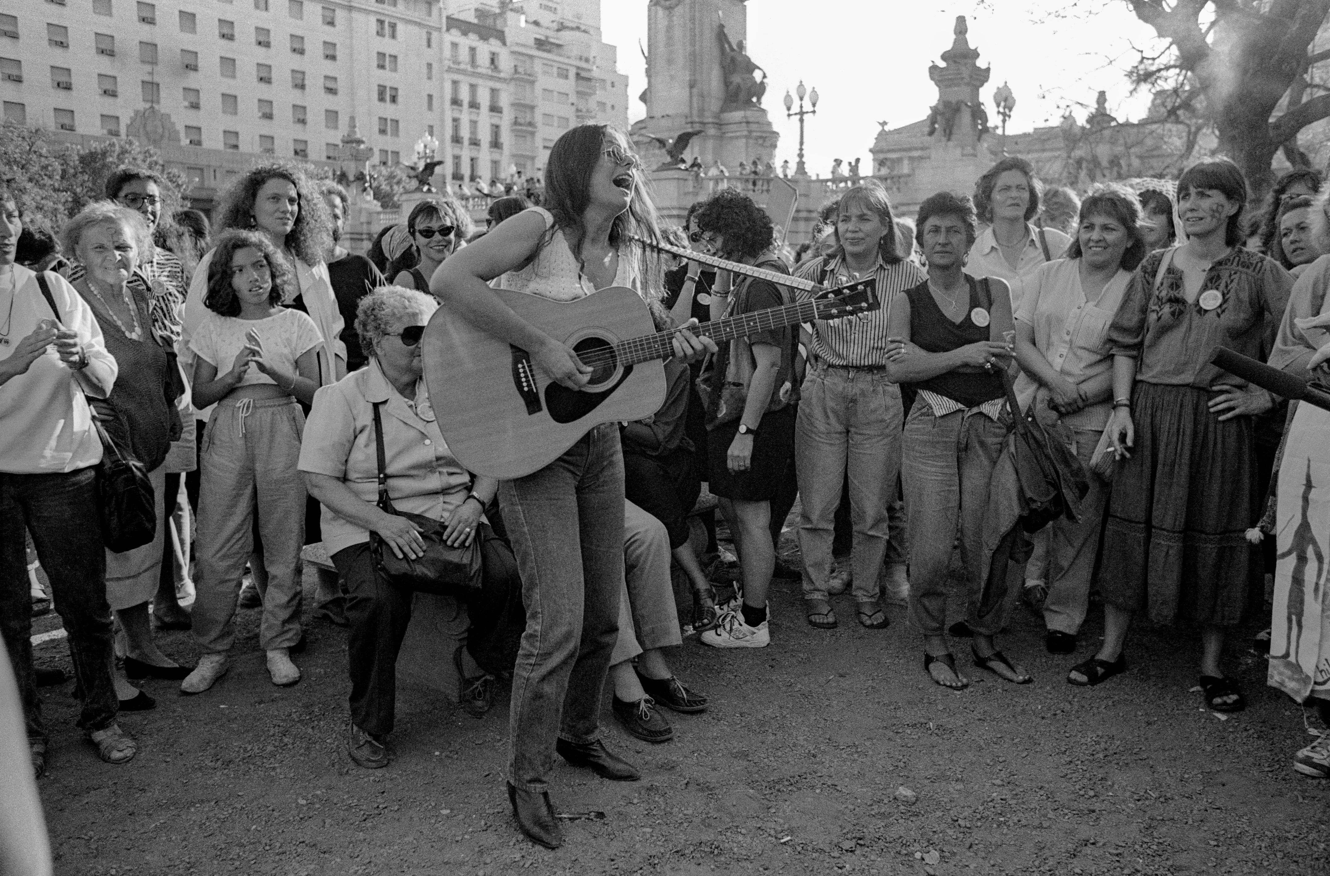 A woman plays an acoustic guitar for participants in the closing march of the 5th <em>Encuentro Feminista Latinoamericano y del Caribe</em> (Feminist Meeting of Latin America and the Caribbean) in San Bernardo, Argentina, on Nov. 24, 1990.