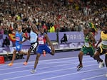 Lyles crosses the finish line ahead of Jamaica's Kishane Thompson in the men's 100m final on Sunday night at Stade de France in Saint-Denis, north of Paris.