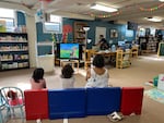 Kids and caretakers watch a "Madeline" DVD in the basement of the Columbia County Library on a hot Tuesday afternoon.