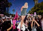 Confetti falls on Britney Spears supporters outside a hearing concerning the pop singer's conservatorship at the Stanley Mosk Courthouse, Friday, Nov. 12, 2021, in Los Angeles. A Los Angeles judge ended the conservatorship that has controlled Spears' life and money for nearly 14 years. (AP Photo/Chris Pizzello)