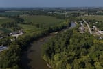 FILE - Water flows down the Sandusky River between farms, Aug. 26, 2024, in Fremont, Ohio.