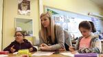 Teacher Michelle Moran, center, helps students with problems during small group work in a late-March class.