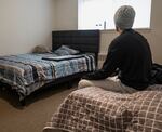 Jefferson, a refugee residing in the Parkview Apartments community in Riverdale, Maryland sits in his bedroom that he shares with his roommate on Feb. 27, 2025.