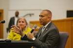 In this photo, House Minority Leader Hakeem Jeffries and Rep. Susan Wild are seated at a table during a roundtable discussion about voting rights in Easton, Pennsylvania, on Oct. 10. Jeffries appears on the right side of the photo, wearing a gray suit and holding a microphone. Wild appears on the left side of the photo, wearing a yellow top and looking toward Jeffries.