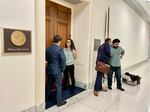 Mary Peltola did interviews in the doorway of her locked office. Here she spoke to a Time reporter. Aides Josh Wilson and Hector Jimenez, right, share a word.