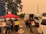 Volunteers serve meals at the state fairgrounds in Salem, where an evacuation center has been established for people fleeing the Santiam Fire.