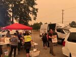 Volunteers serve meals at the state fairgrounds in Salem, where an evacuation center has been established for people fleeing the Santiam Fire.