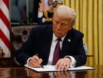 President Donald Trump signs executive orders in the Oval Office.