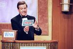 Host Wink Martindale looks at a card during game show in 1997.