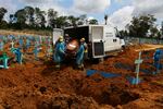 Cemetery workers carry the remains of 89-year-old Abilio Ribeiro, who died of the new coronavirus, to bury at the Nossa Senhora Aparecida cemetery in Manaus, Amazonas state, Brazil, Wednesday, Jan. 6, 2021. Manaus declared on Jan. 5 a 180-day state of emergency due to a surge of new cases of coronavirus.