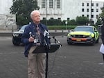 Oregon Senate President Peter Courtney, D-Salem, holds up a smartphone at a state capitol press conference. 