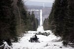 A U.S. border patrol agent rides an ATV along "The Slash"— the boundary marker cut into the forest — marking the line between Canadian territory on the right and the U.S., near Beecher Falls, Vermont.